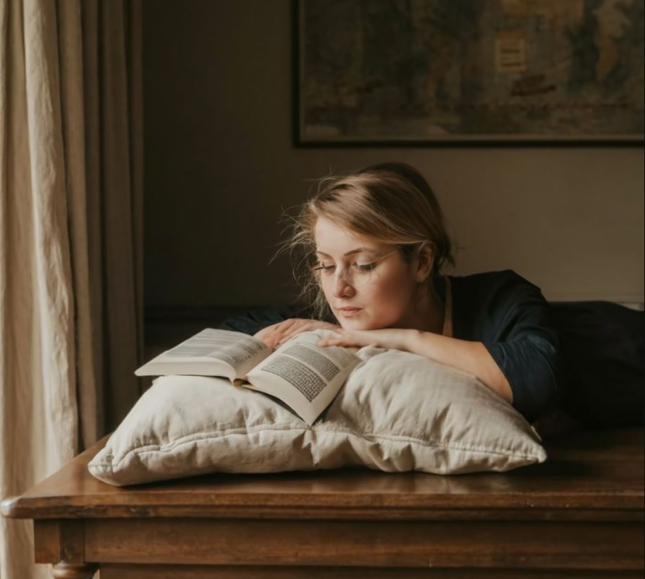 femme qui lit un livre sur un coussin